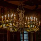 ...� illuminato da un appariscente lampadario in ferro battuto
